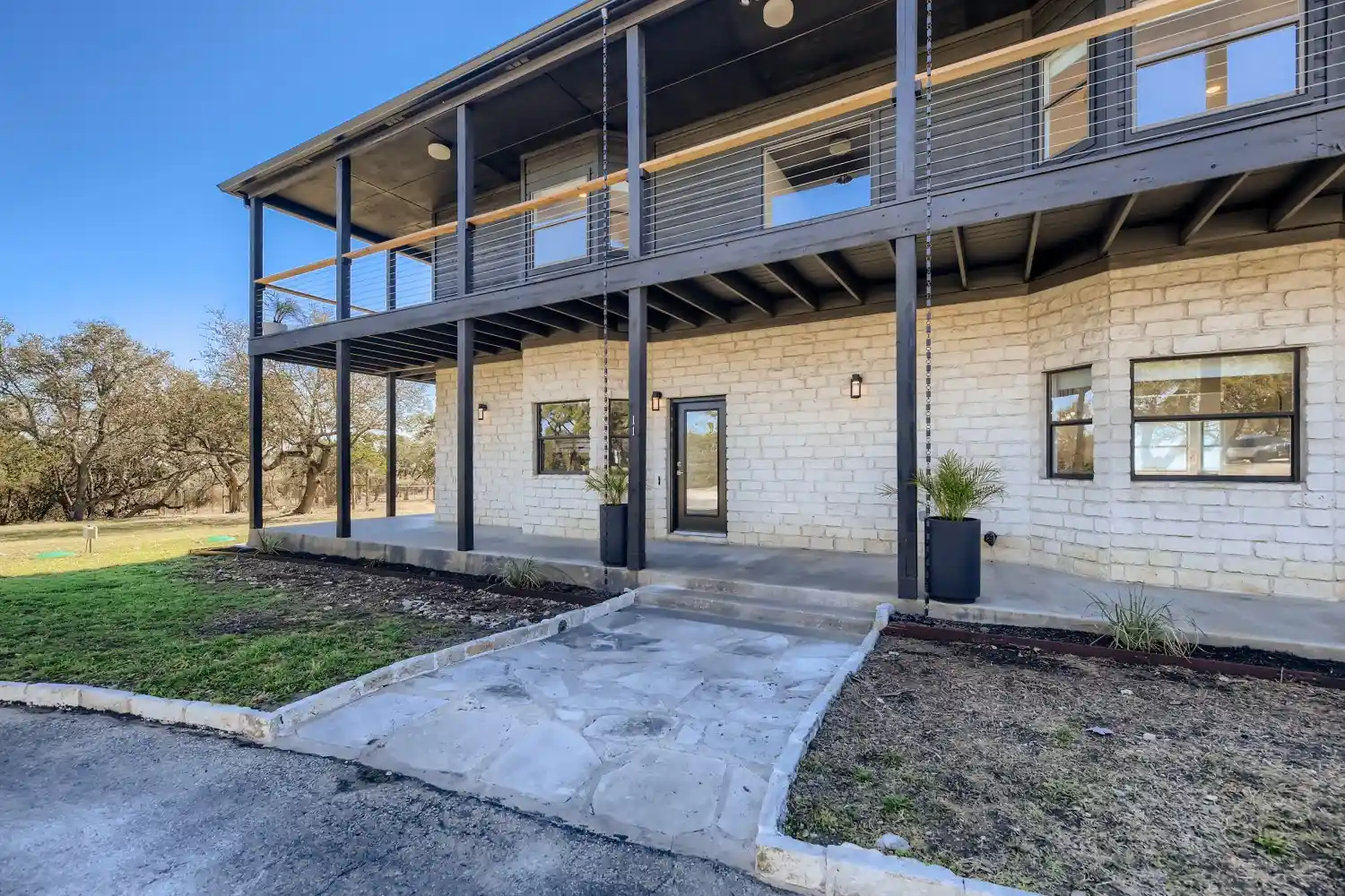 Mastering Airbnb Hosting: 15 Essential Tips for Success 1 Limestone home with two stories including a covered balcony and patio.