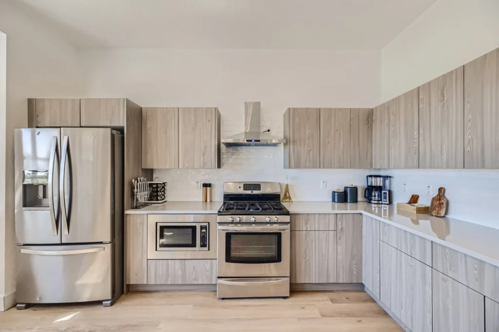 Mastering Airbnb Hosting: 15 Essential Tips for Success 3 Airbnb kitchen with light taupe cabinetry, oven, range, microwave, and refrigerator.