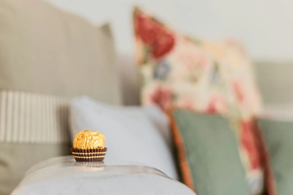 The Ultimate Airbnb Host Checklist: Maximize Your Rental Potential with Hostly 2 Ferrero Rochet chocolate on pillow on the bed in an Airbnb in Austin.